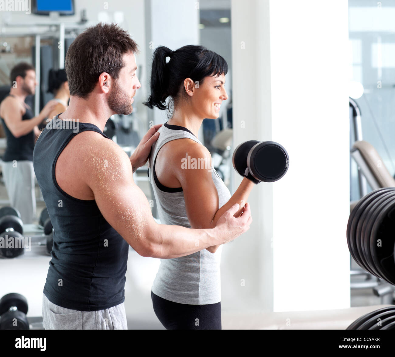 gym woman personal trainer man with weight training equipment Stock Photo