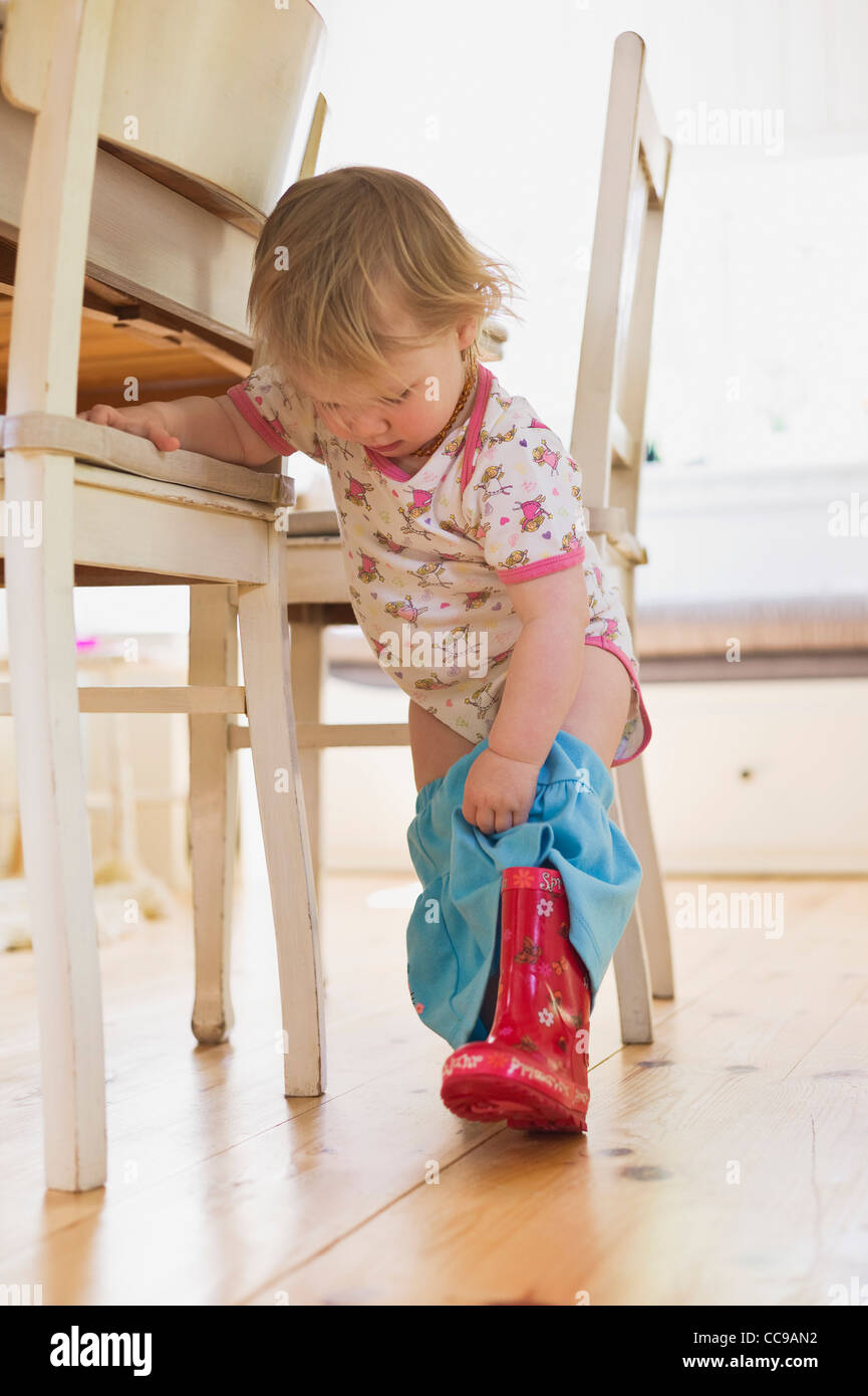Girl Putting on Rubber Boots Stock Photo Alamy