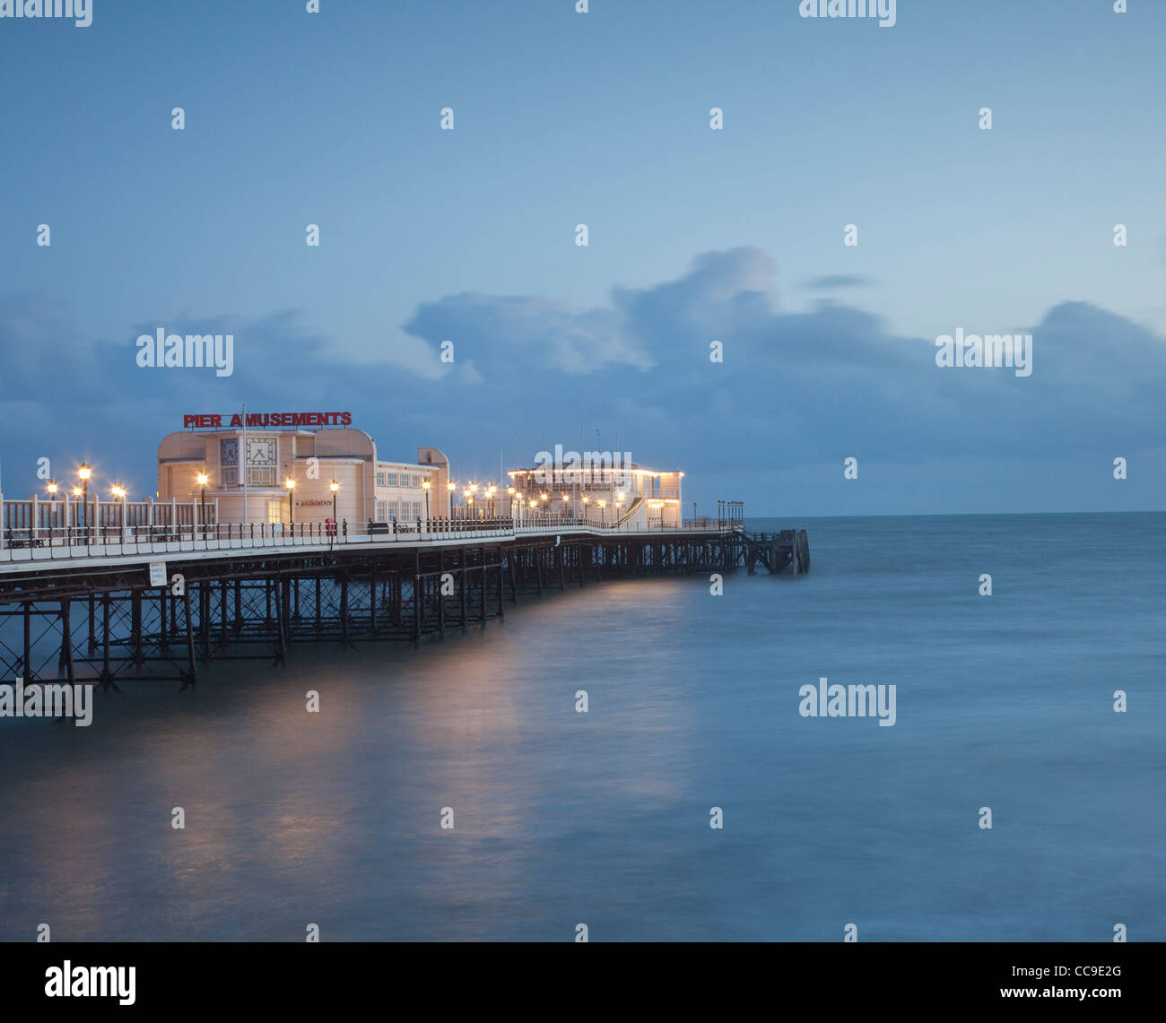 Evening view of Worthing pier, Sussex, illuminated at sunset. Stock Photo