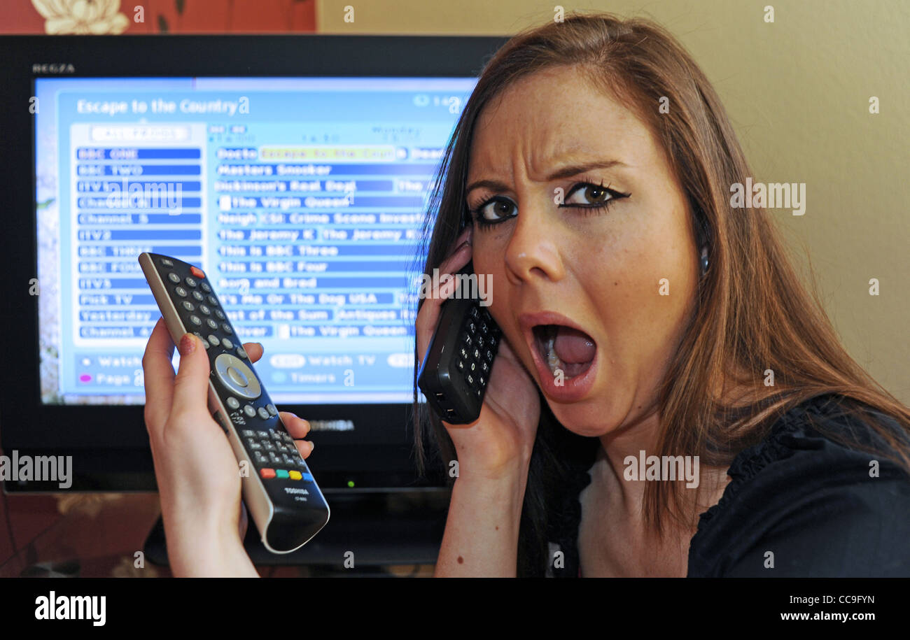 Young woman having trouble with the Digital Television Switchover in the UK phones a helpline Stock Photo