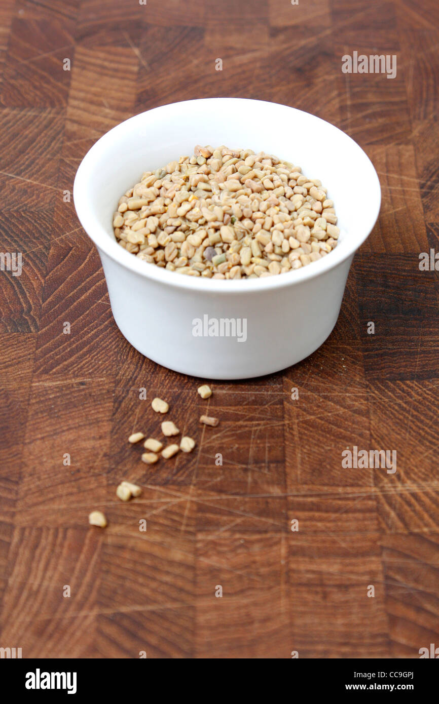 Fenugreek seeds on a brown surface Stock Photo
