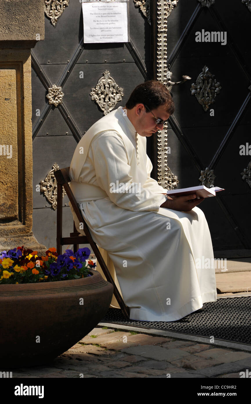 priest  reading a book outside a church in Prague Czech Republic Stock Photo