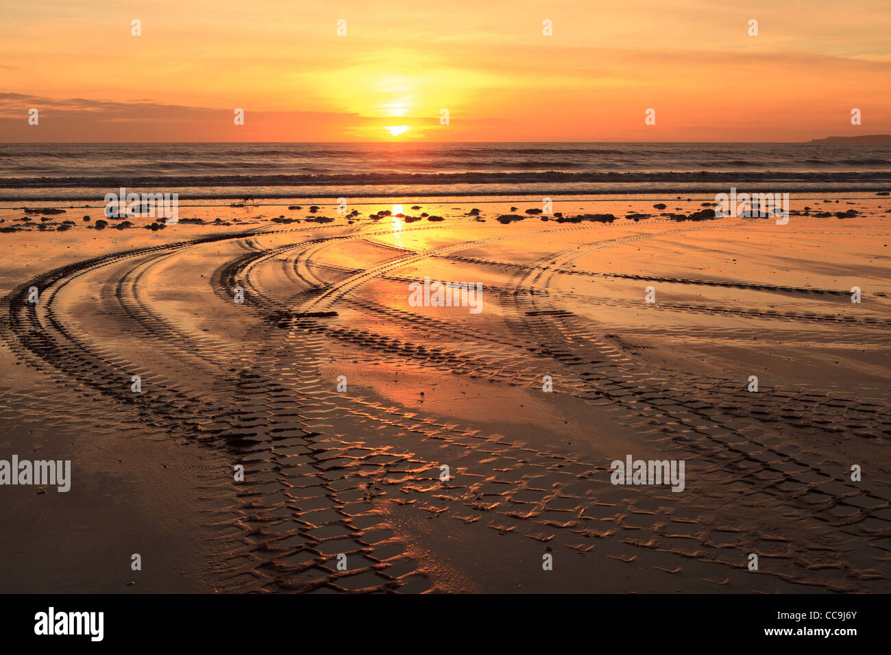 Tractor trails in Sunset, Aberavon Beach, Port Talbot, South Wales, UK Stock Photo
