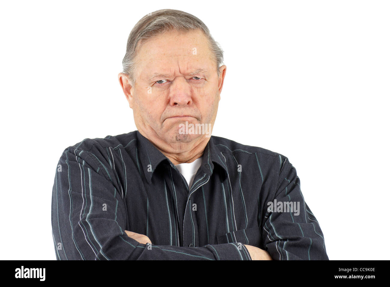 Senior man with arms crossed looking very grumpy, unhappy or mad. Stock Photo