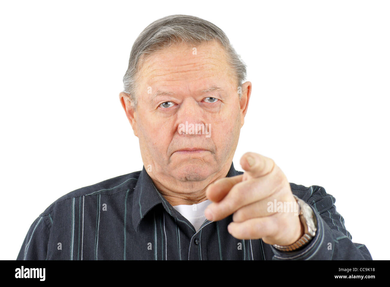Portrait of old senior man pointing at camera looking angry. Stock Photo