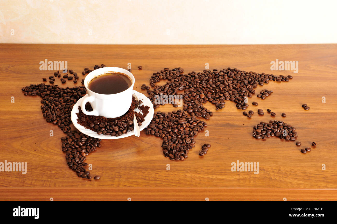 Dramatic photo of world map made of coffee beans. White cup with hot drink Stock Photo