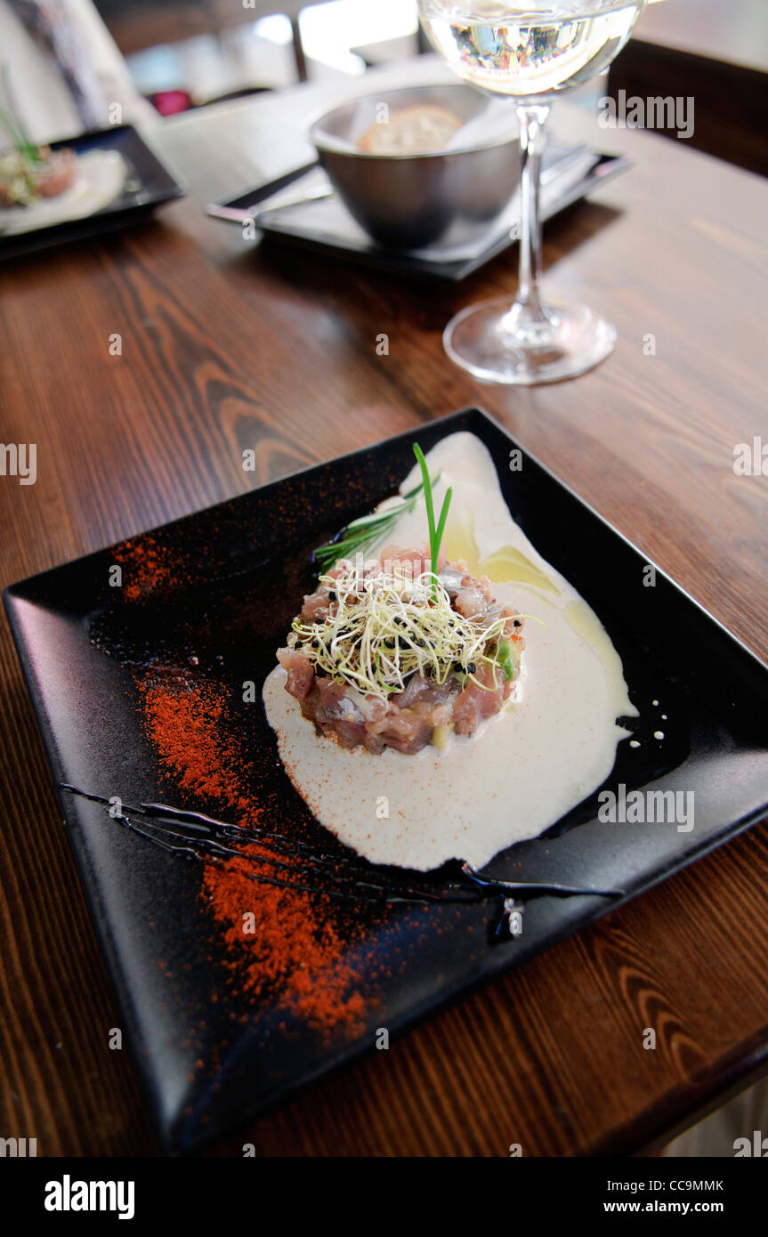 modern Tapa of raw fish with white sauce on table in restaurant in the old town of Benidorm, Spain Stock Photo