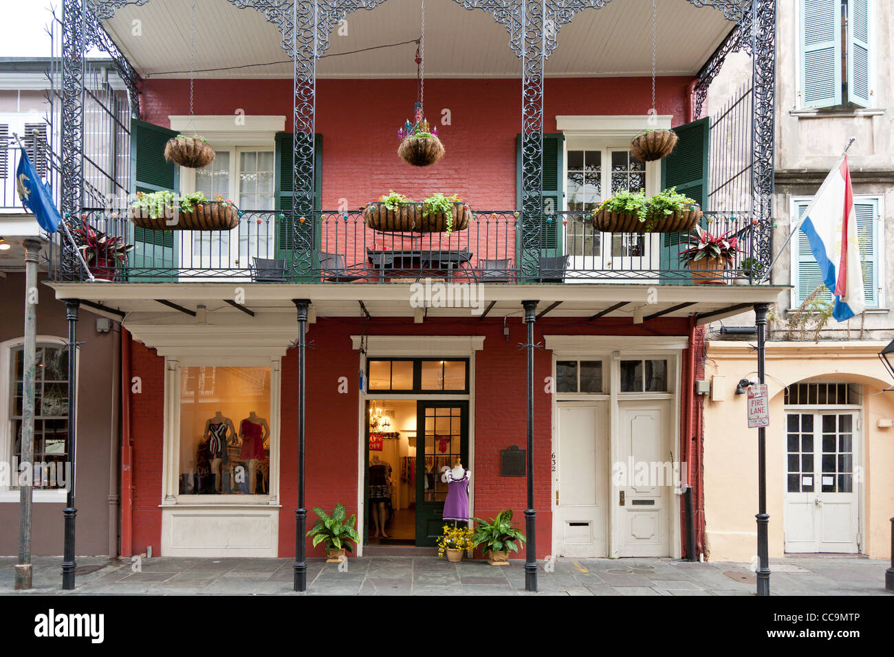 Upscale dress shop under balcony with decorative wrought iron railings in the French Quarter of