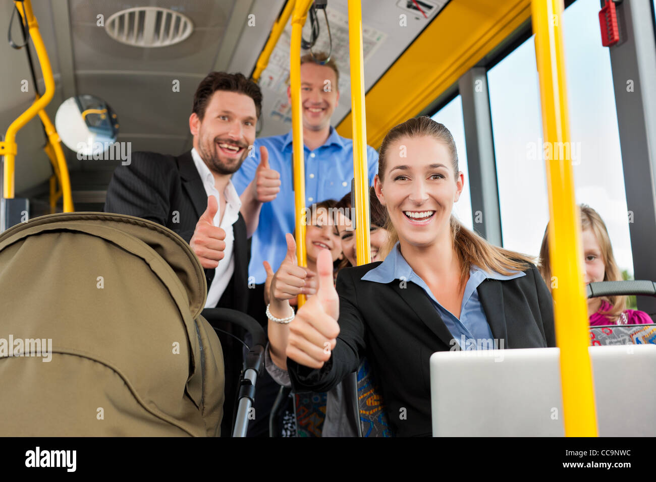 Passengers in a bus - a commuter, a father with a stroller, a man, children; all with thumps up Stock Photo