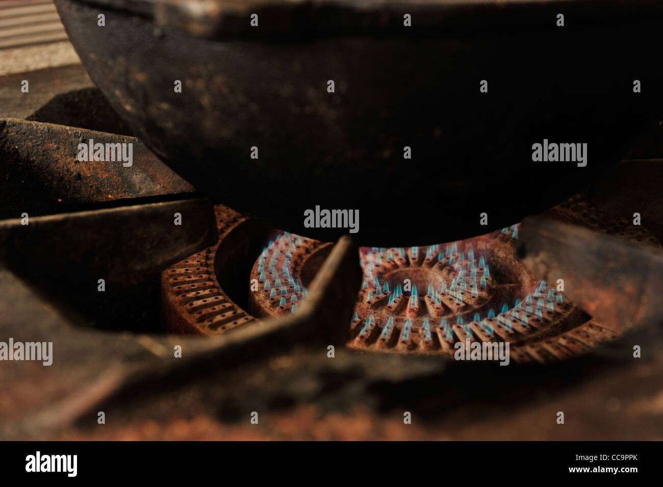 Closeup photo of old rusty gas stove with burning flame and cooking ...