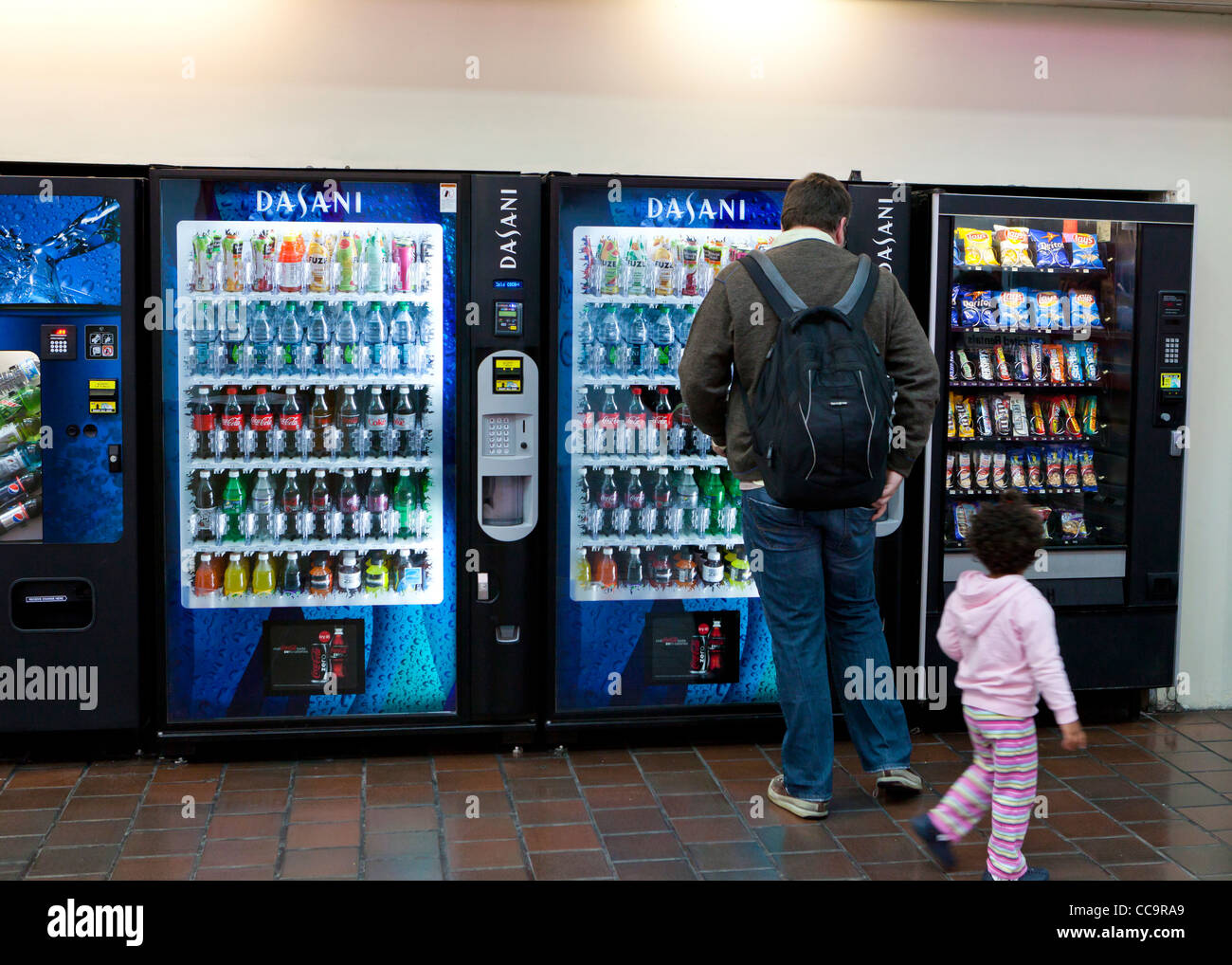 A man and child standing in front of soft drink vending machine - USA Stock Photo