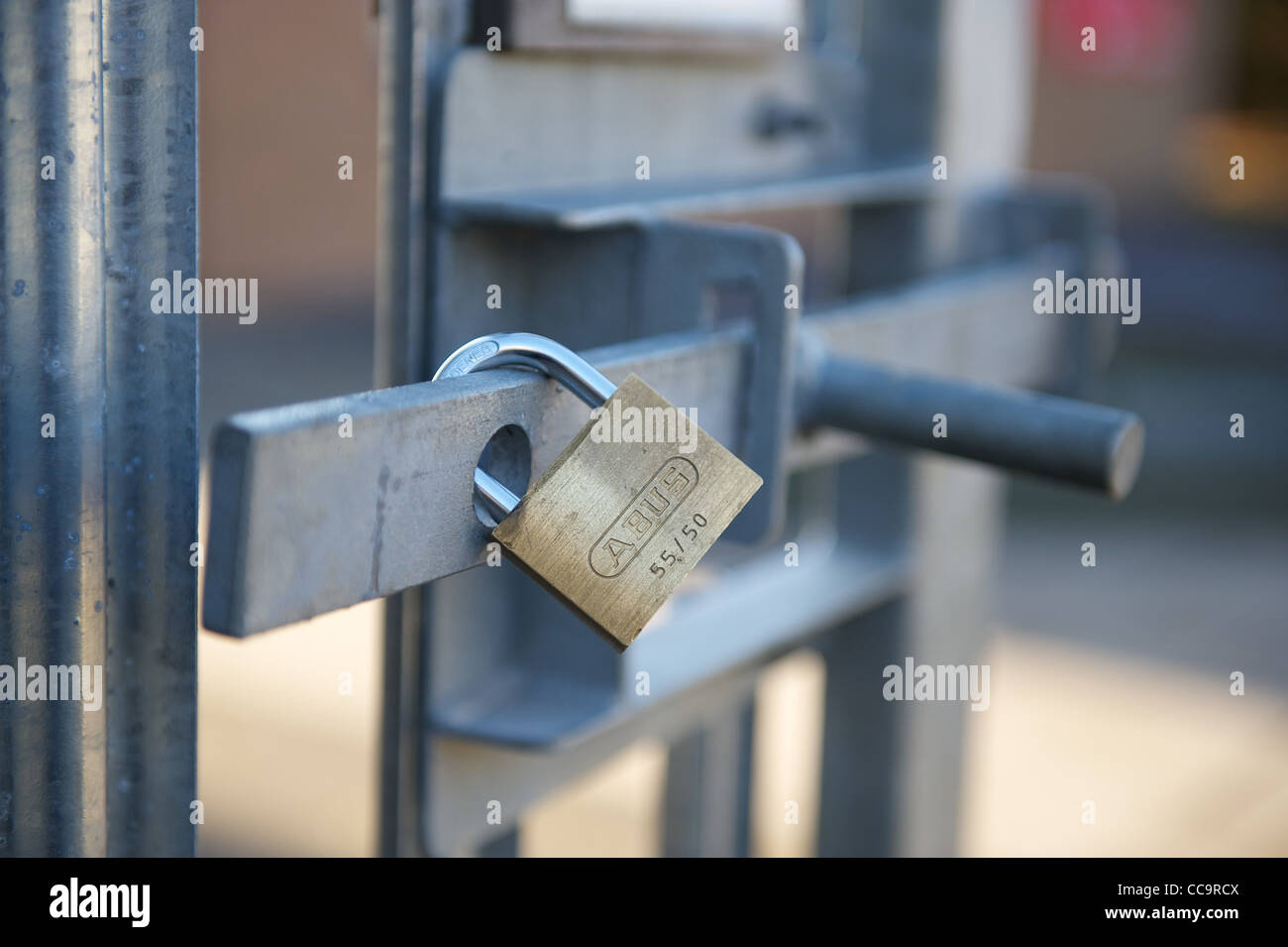 Locked steel padlock on a metal gate Stock Photo