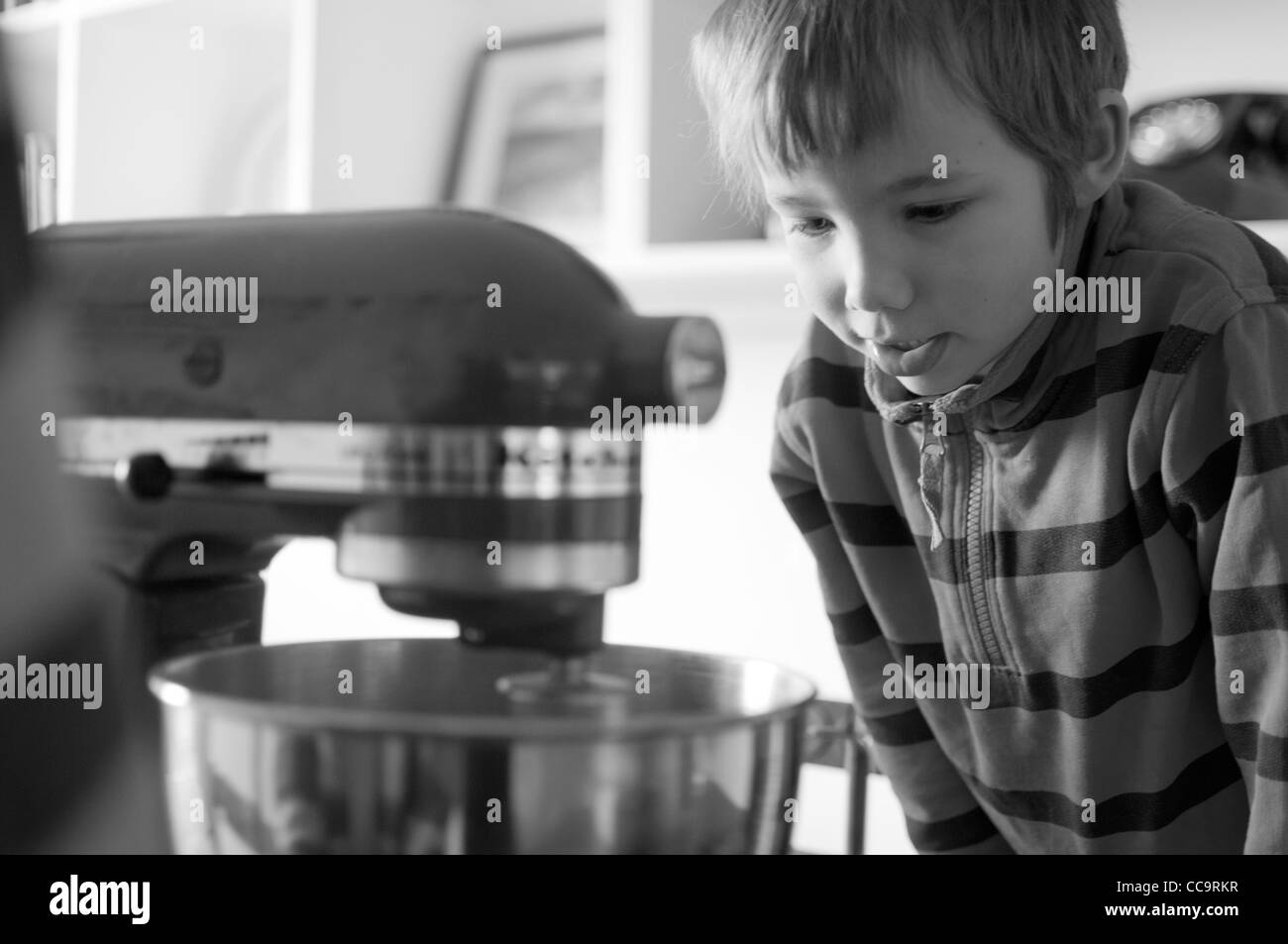 Young boy in the kitchen making a chocolate cake with a kitchenaid mixer. Stock Photo