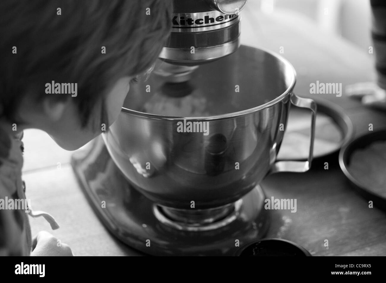 Young boy in the kitchen making a chocolate cake. Stock Photo