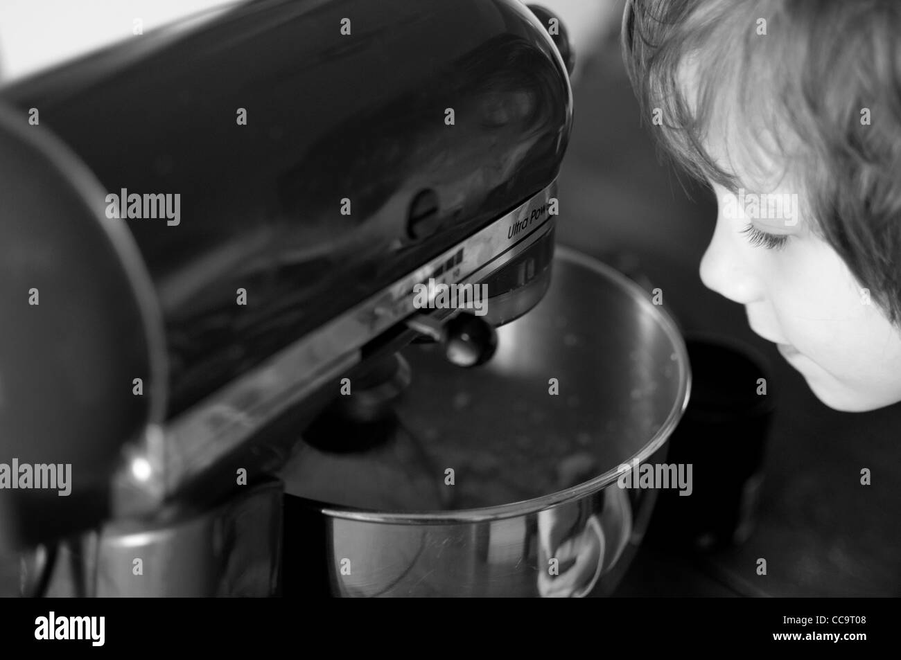 Young boy in the kitchen making a chocolate cake. Stock Photo