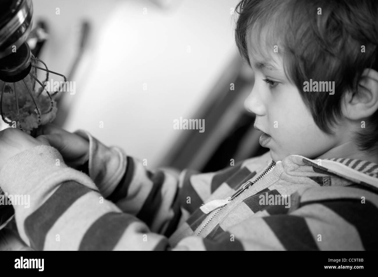 Young boy in the kitchen making a chocolate cake. Stock Photo