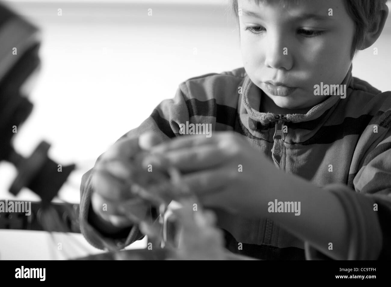 Young boy in the kitchen making a chocolate cake. Stock Photo