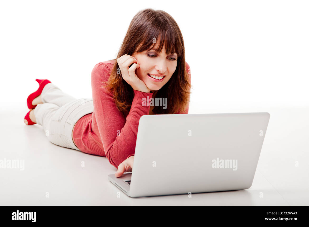 Beautiful woman lying on the floor and working on a laptop Stock Photo ...