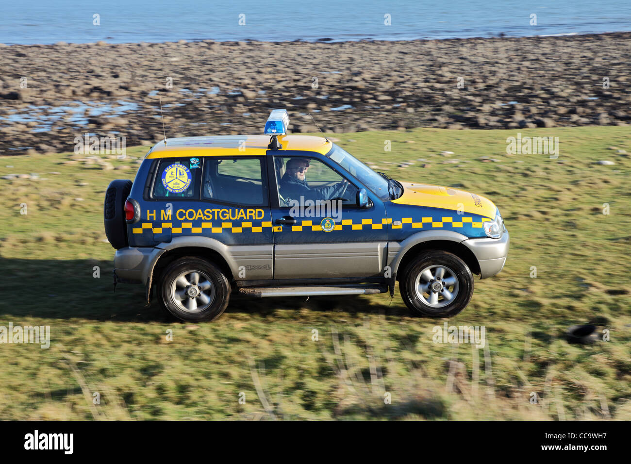 HM coastguard Nissan Terrano vehicle travelling at speed over rough ground Holy Island, north east England, UKspee Stock Photo