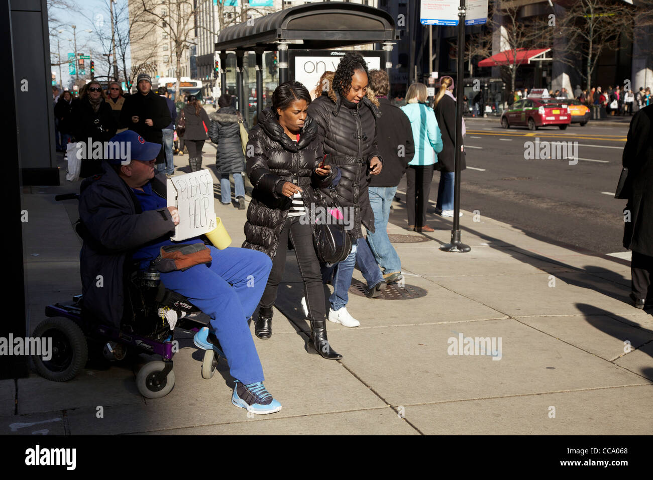Man in motorized wheelchair, pedestrians on Michigan Avenue Chicago