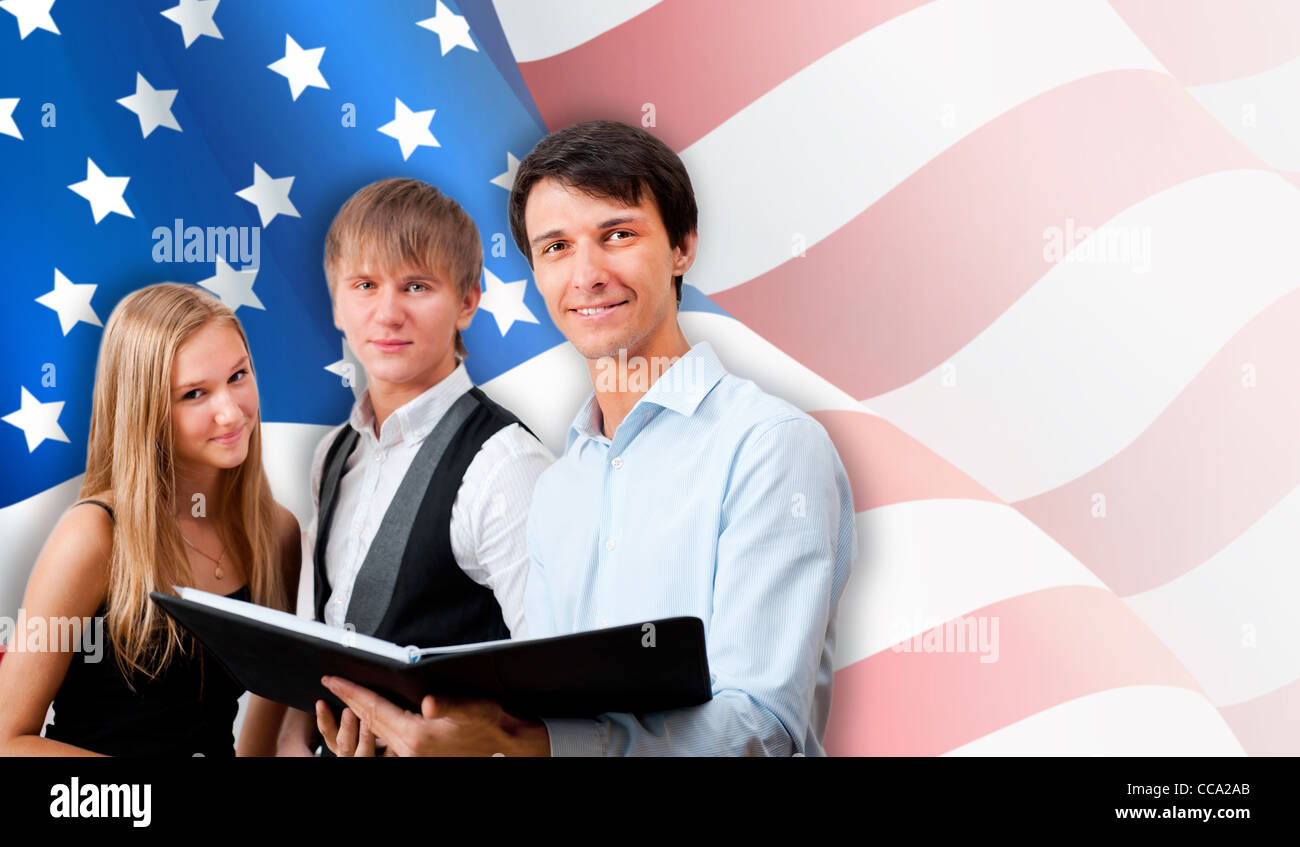 Group of young students standing with their teacher against American Flag. Copyspace Stock Photo