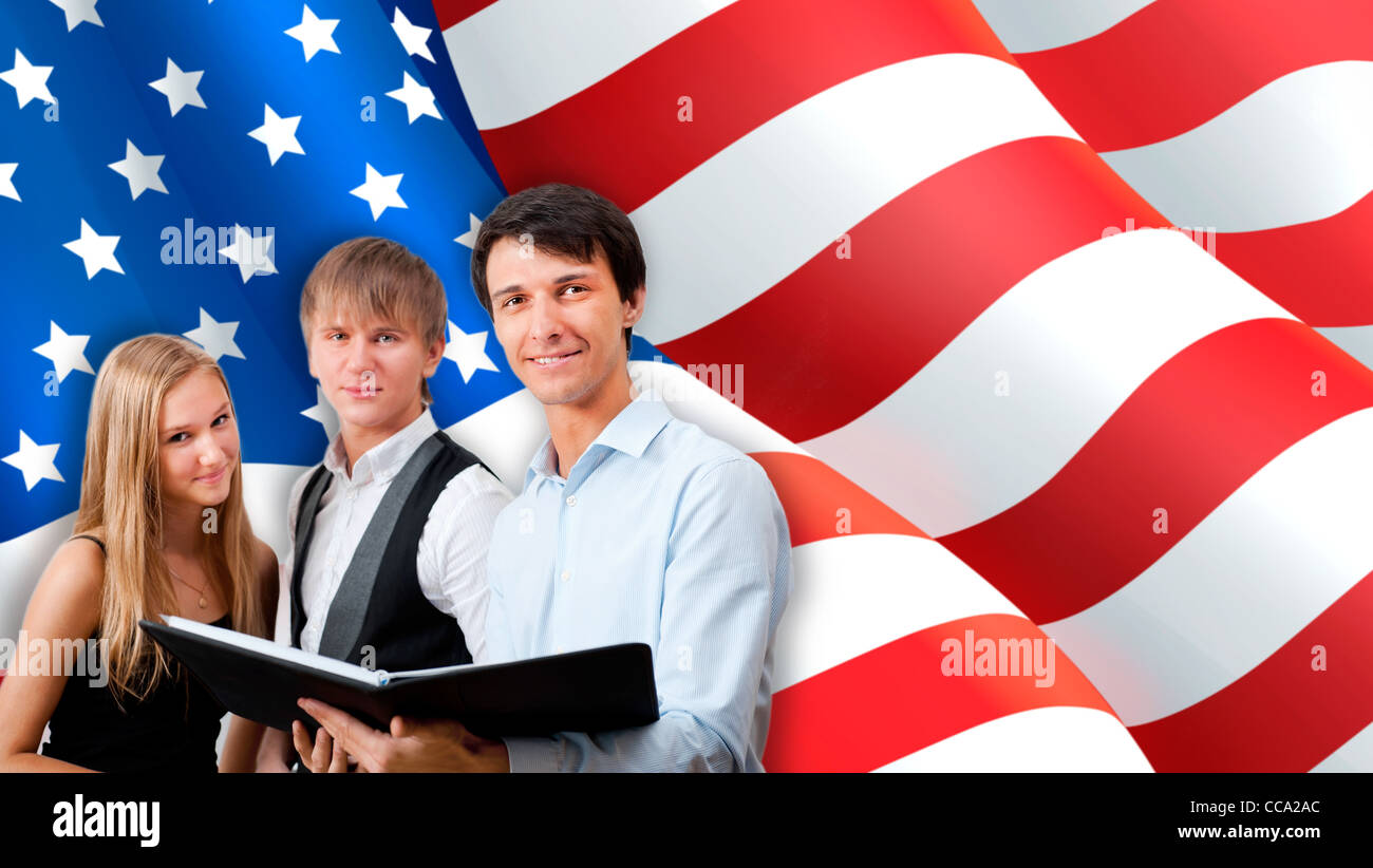 Group of young students standing with their teacher against American Flag. Stock Photo
