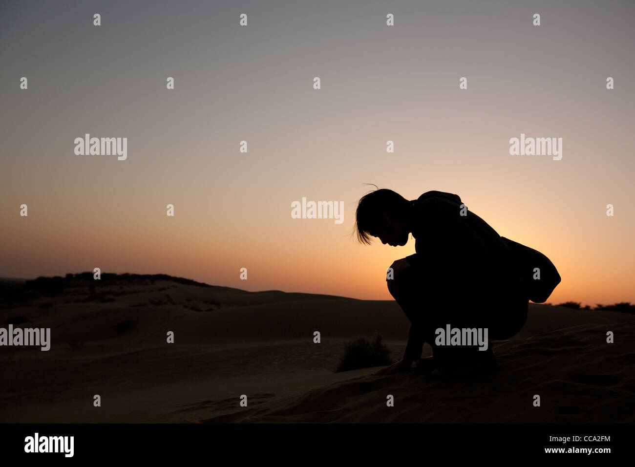 Girl kneeling in the sand hi-res stock photography and images - Alamy