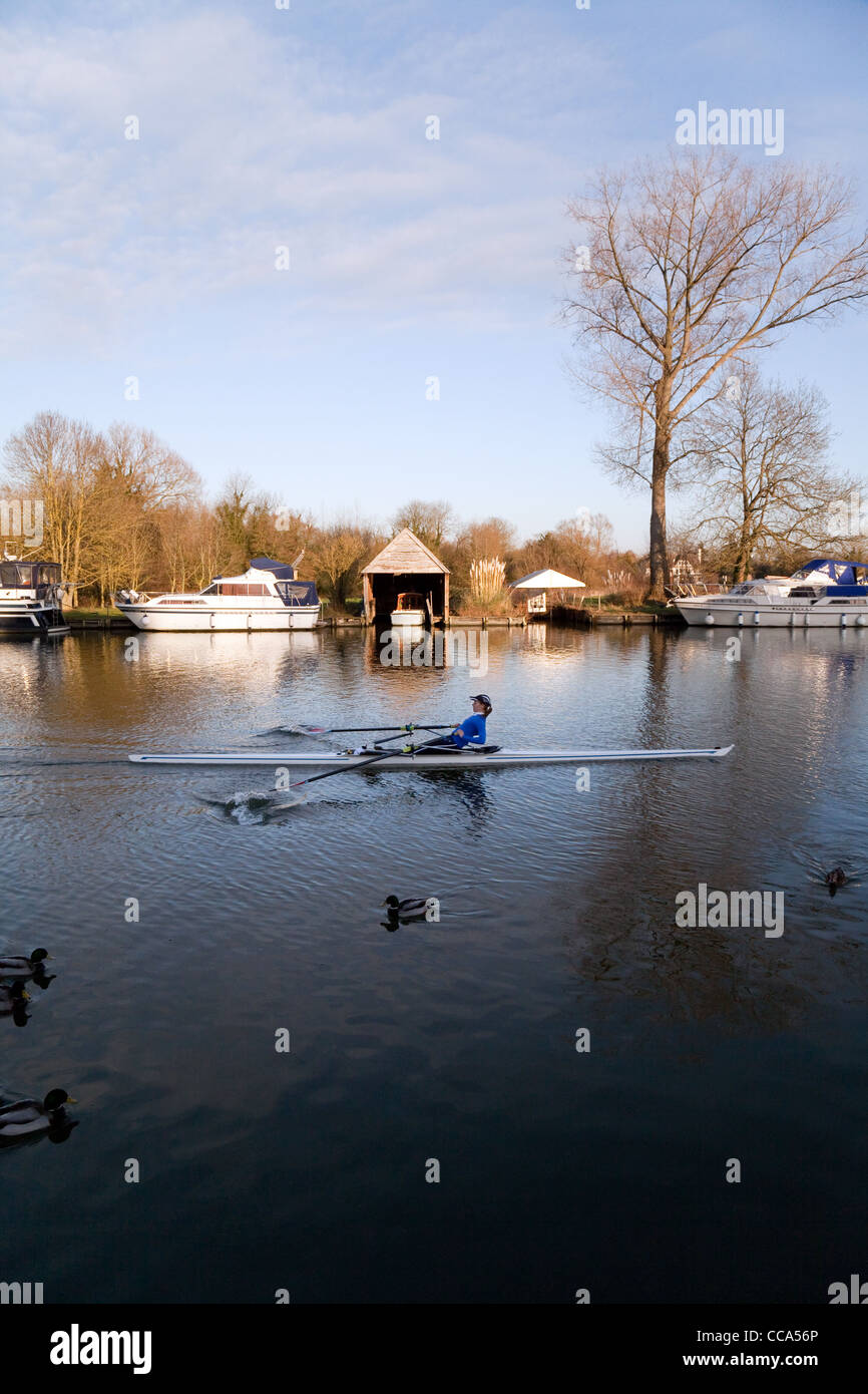 An sculler rowing on the River Thames at Moulsford, Oxfordshire, UK