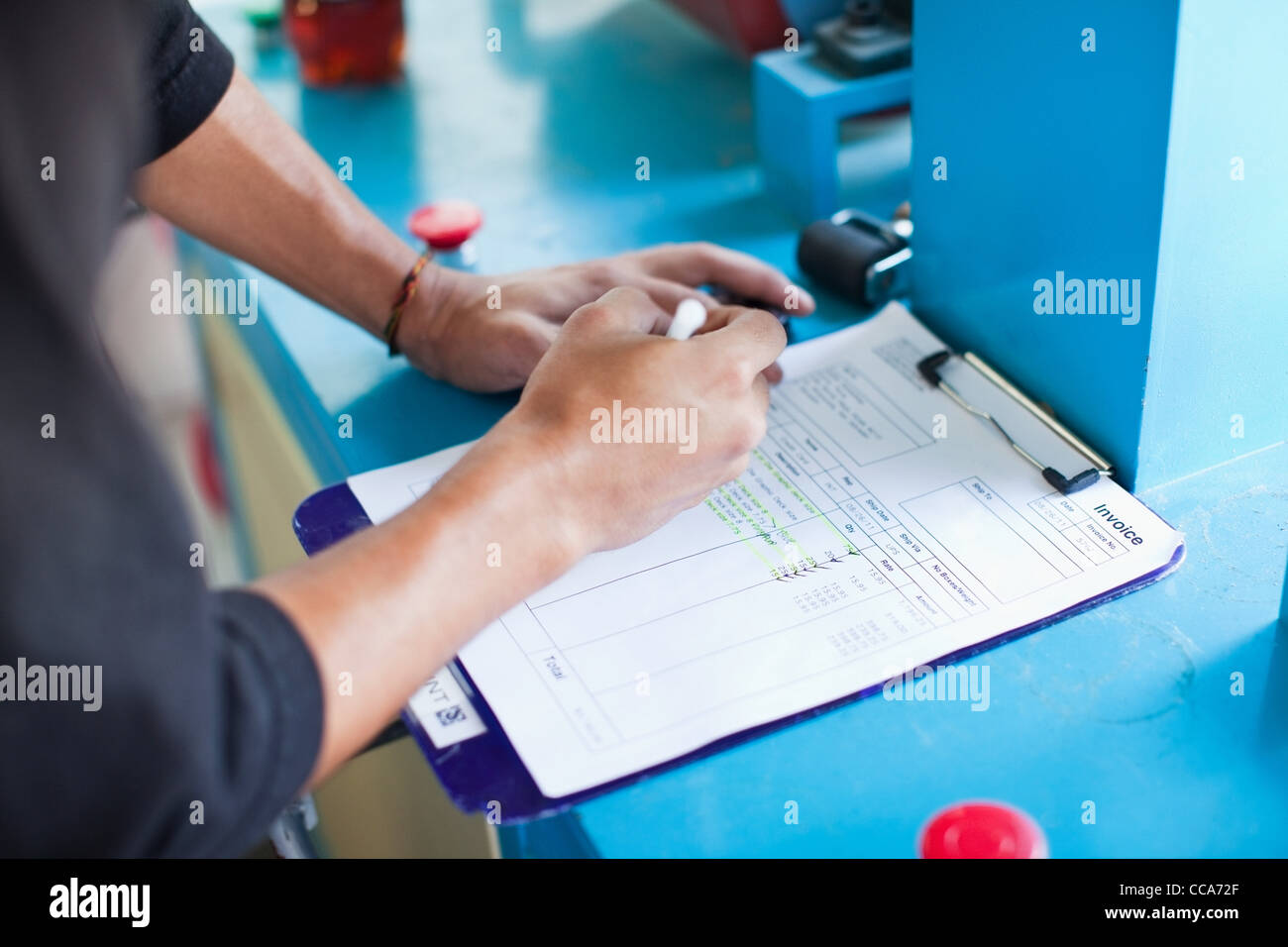 Man checking off items on an invoice Stock Photo