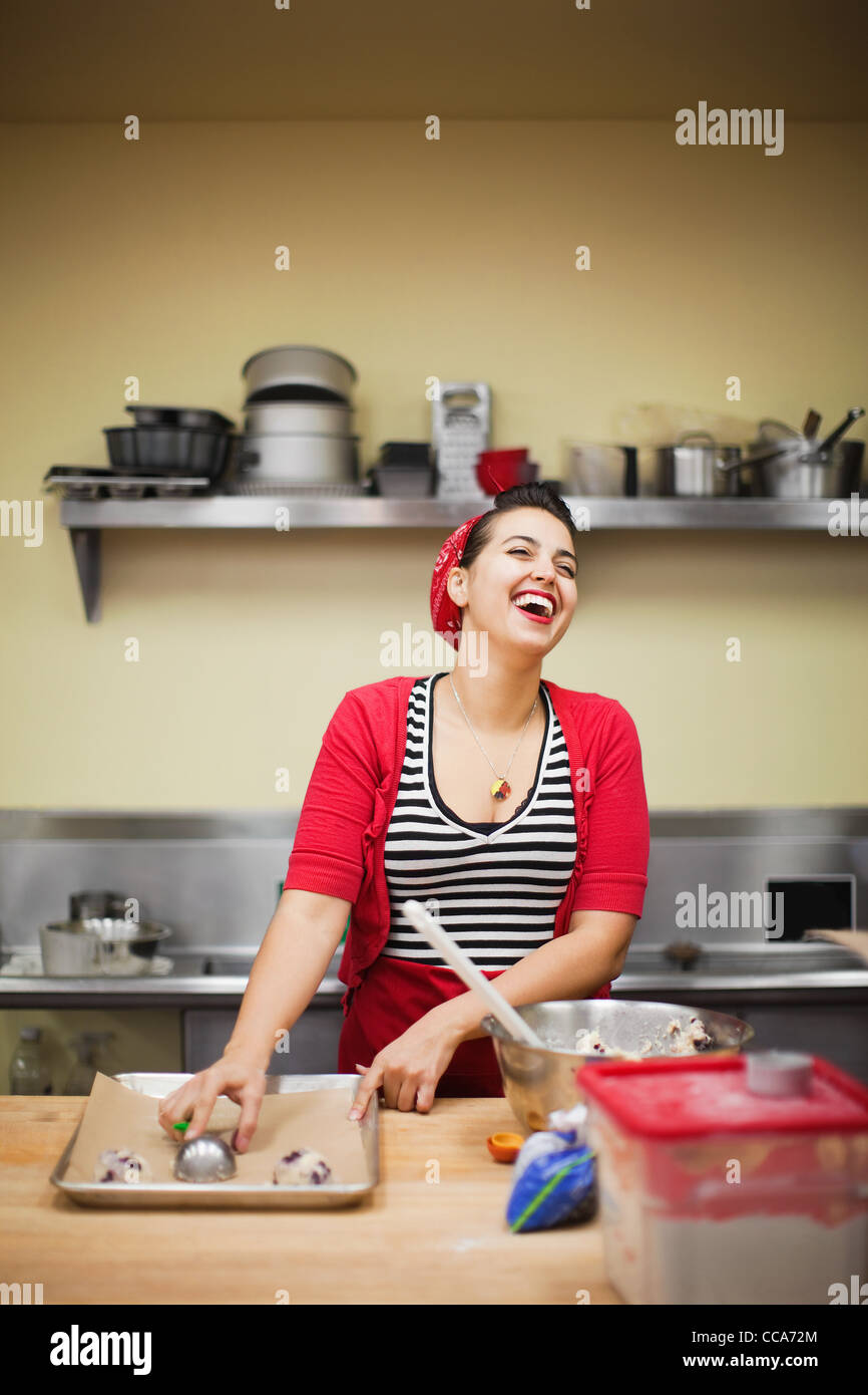 Young baker laughing while preparing food Stock Photo