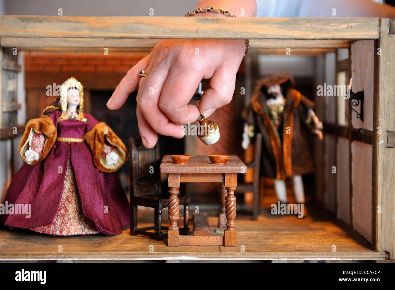 Kit Meggitt arranges items in her Tudor Aristocrats Solar Room displayed at 'Miniatura' - the dolls house and miniature modellin Stock Photo