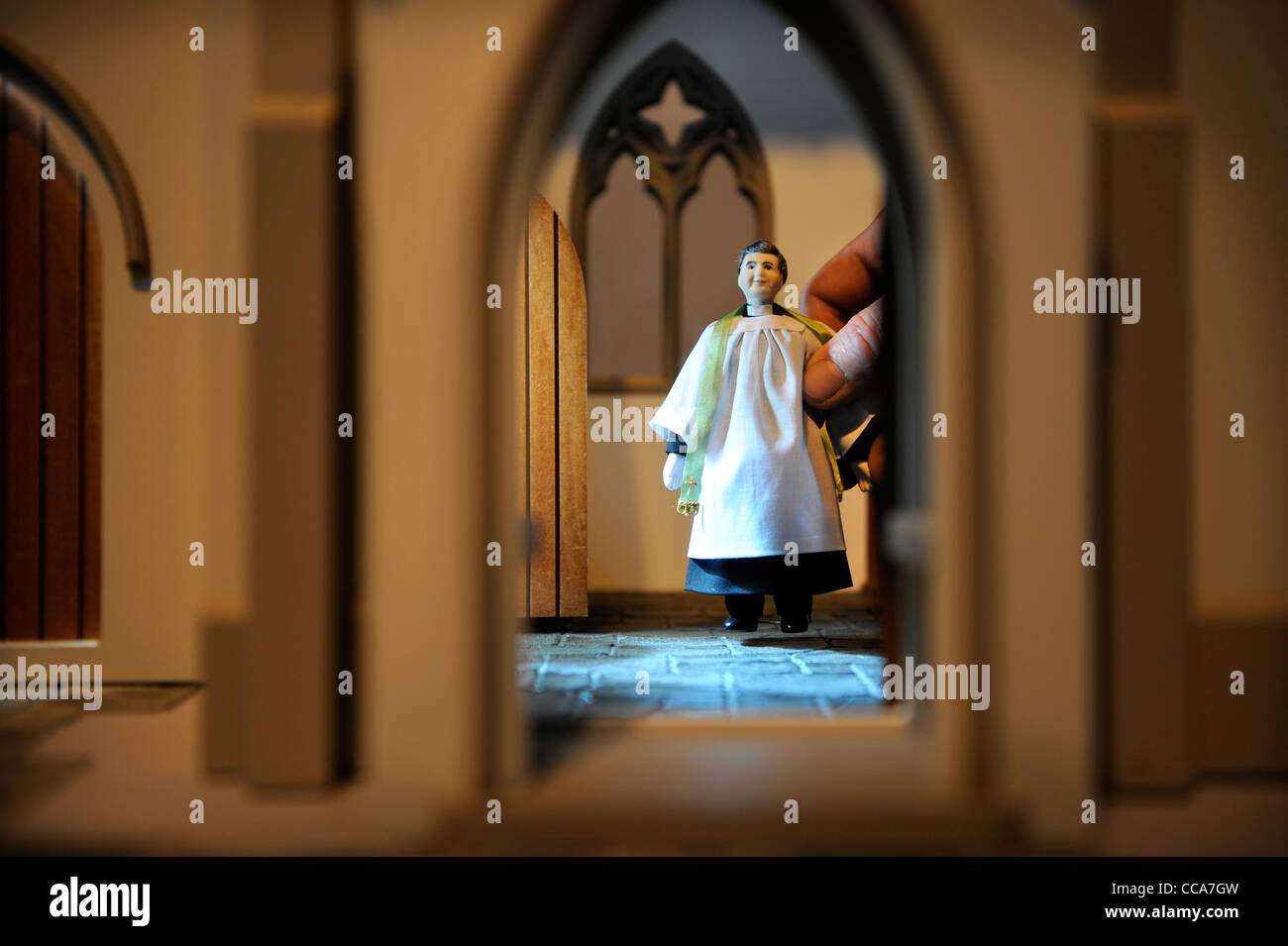 A vicar by Wooside Dolls is placed inside 'All Saints Church' by Barbara's Mouldings at 'Miniatura' - the dolls house and miniat Stock Photo