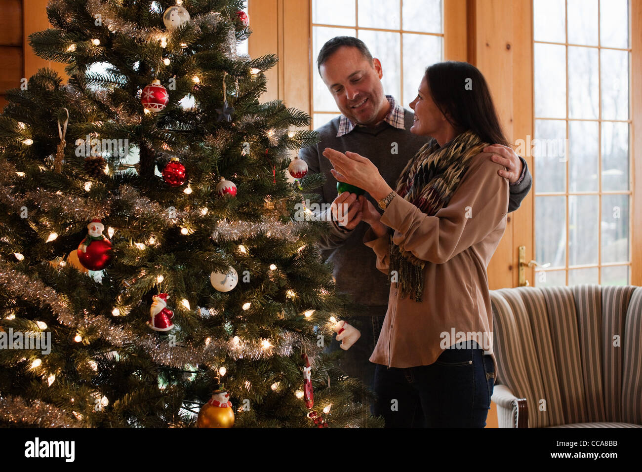 Mature couple decorating christmas tree hires stock photography and