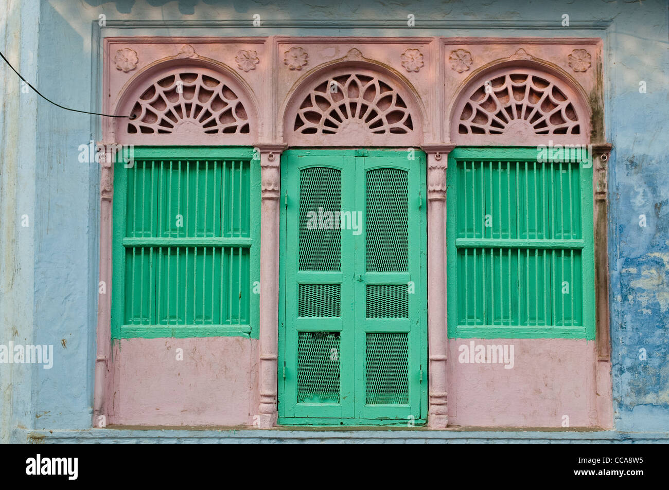 House with green door and windows in a pink frame, Vrindavan, Uttar Pradesh, India Stock Photo