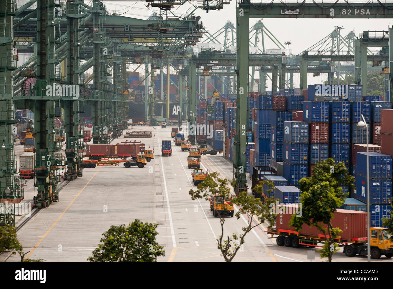 Trucks transport containers at the quayside of the Brani Terminal at