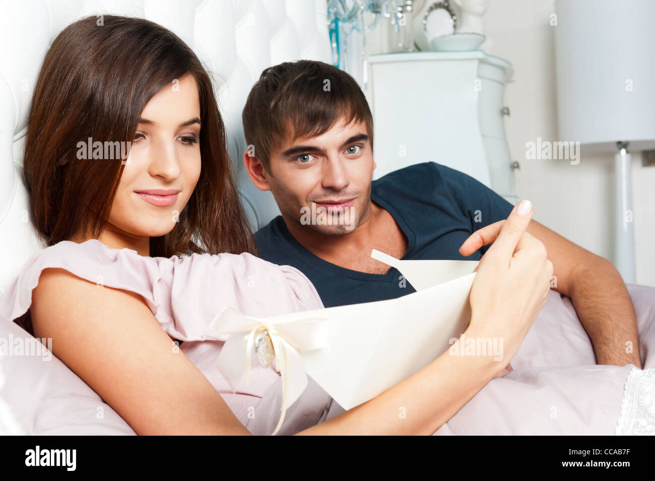 Closeup Portrait of a happy young couple relaxing on the bed. Man ...