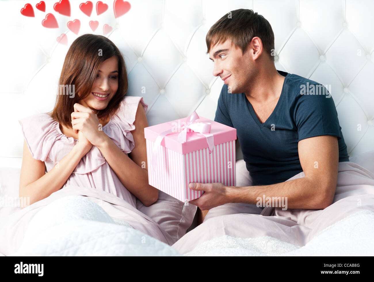 Closeup Portrait of a happy young couple relaxing on the bed. Man ...