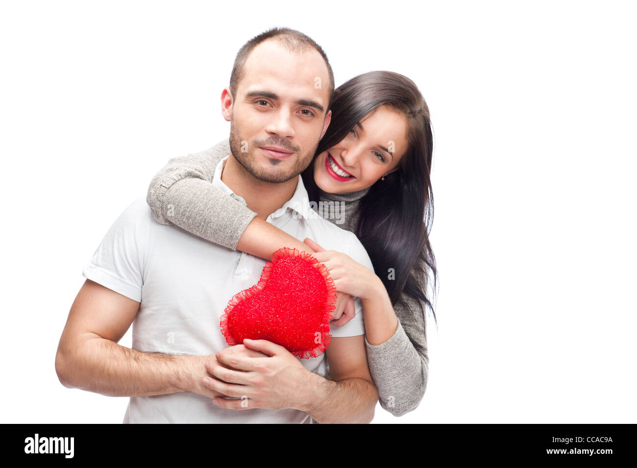 Happy young adult couple with red heart on white background, embracing ...