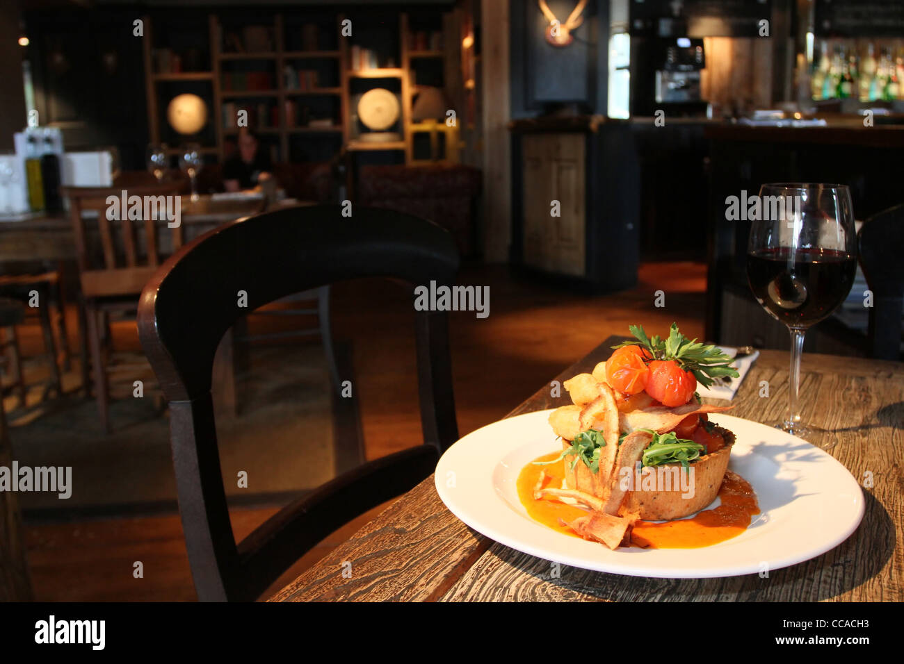 Black olive & onion tart with roasted vegetables in a gastropub setting Stock Photo