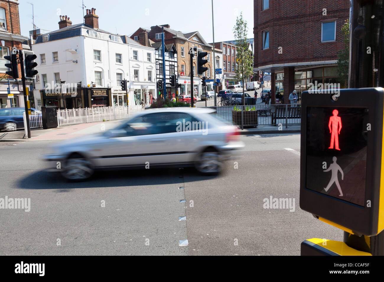 Pedestrian crossing set to red with blurred car in background. Stock Photo