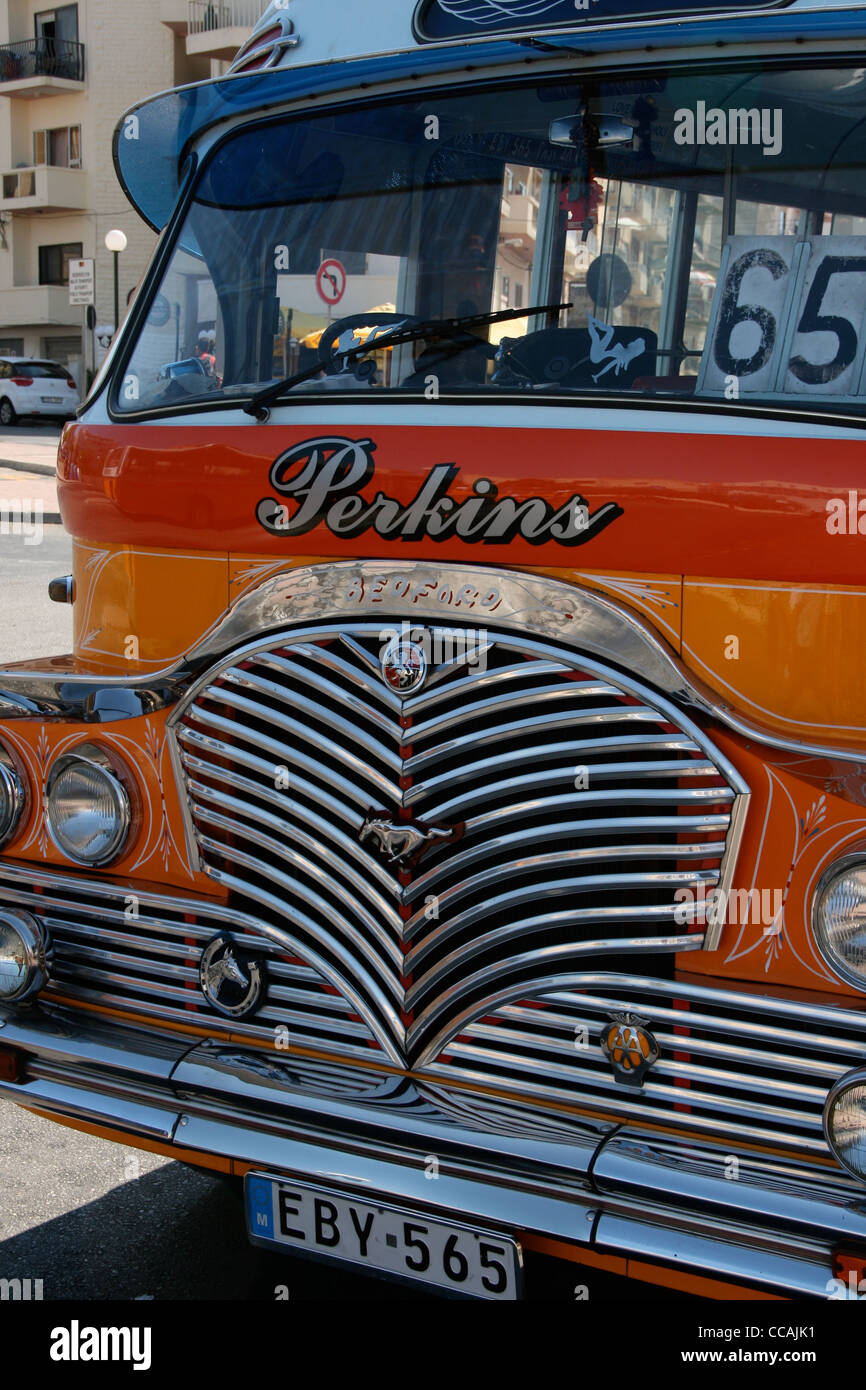 Classic old fashioned Malta bus in traditional colours of yellow and orange and white roof with chrome radiator grille. Stock Photo