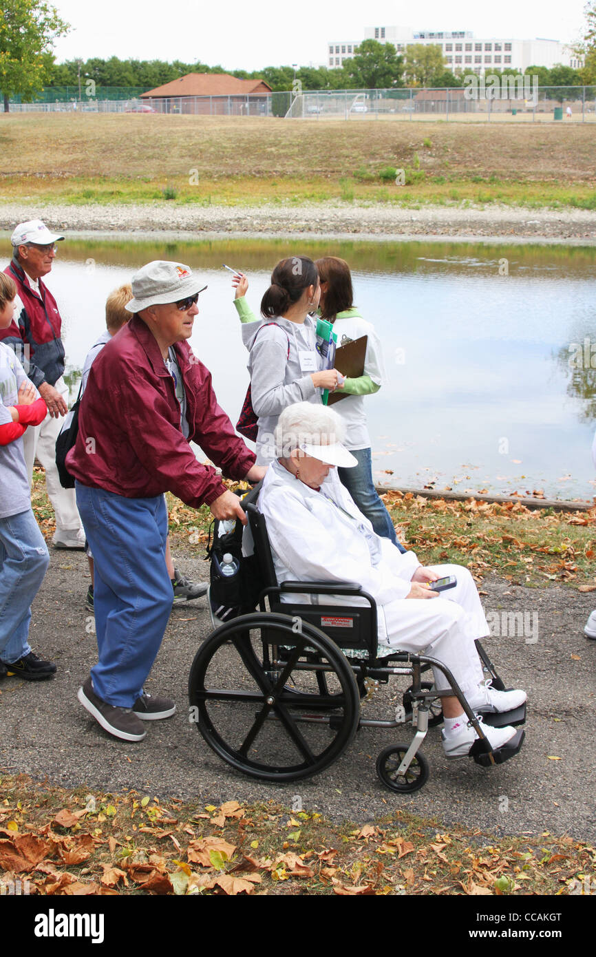 Elderly man with woman in wheelchair at Alzheimer's Memory Walk, Old River Park, Dayton, Ohio, USA. 26 September 2010. Stock Photo