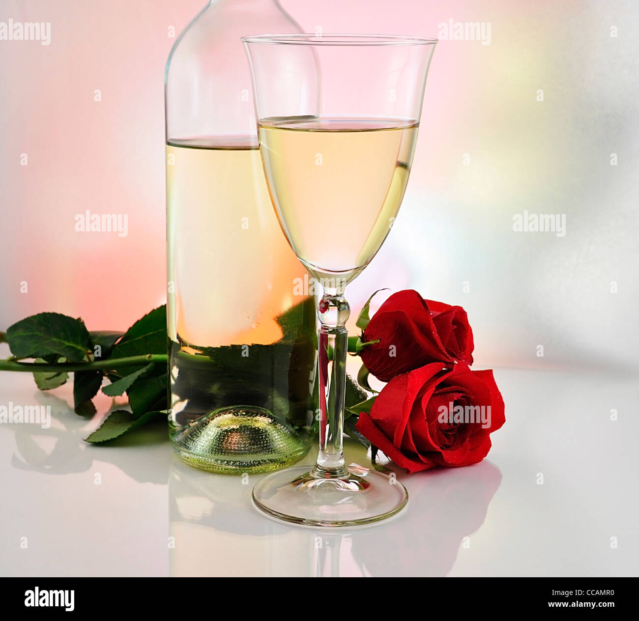 a glass of white wine with bottle and roses Stock Photo - Alamy