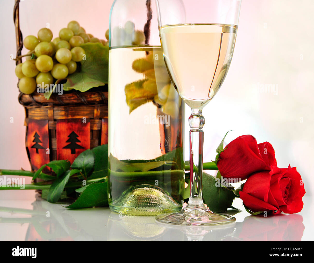 a glass of white wine with bottle and roses Stock Photo - Alamy