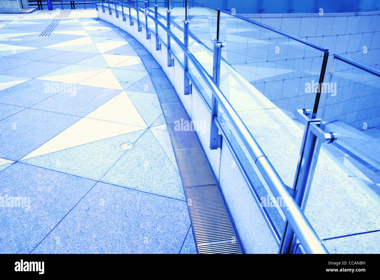 tiled floor, metallic handrails and glass fence fragments of modern urban square Stock Photo