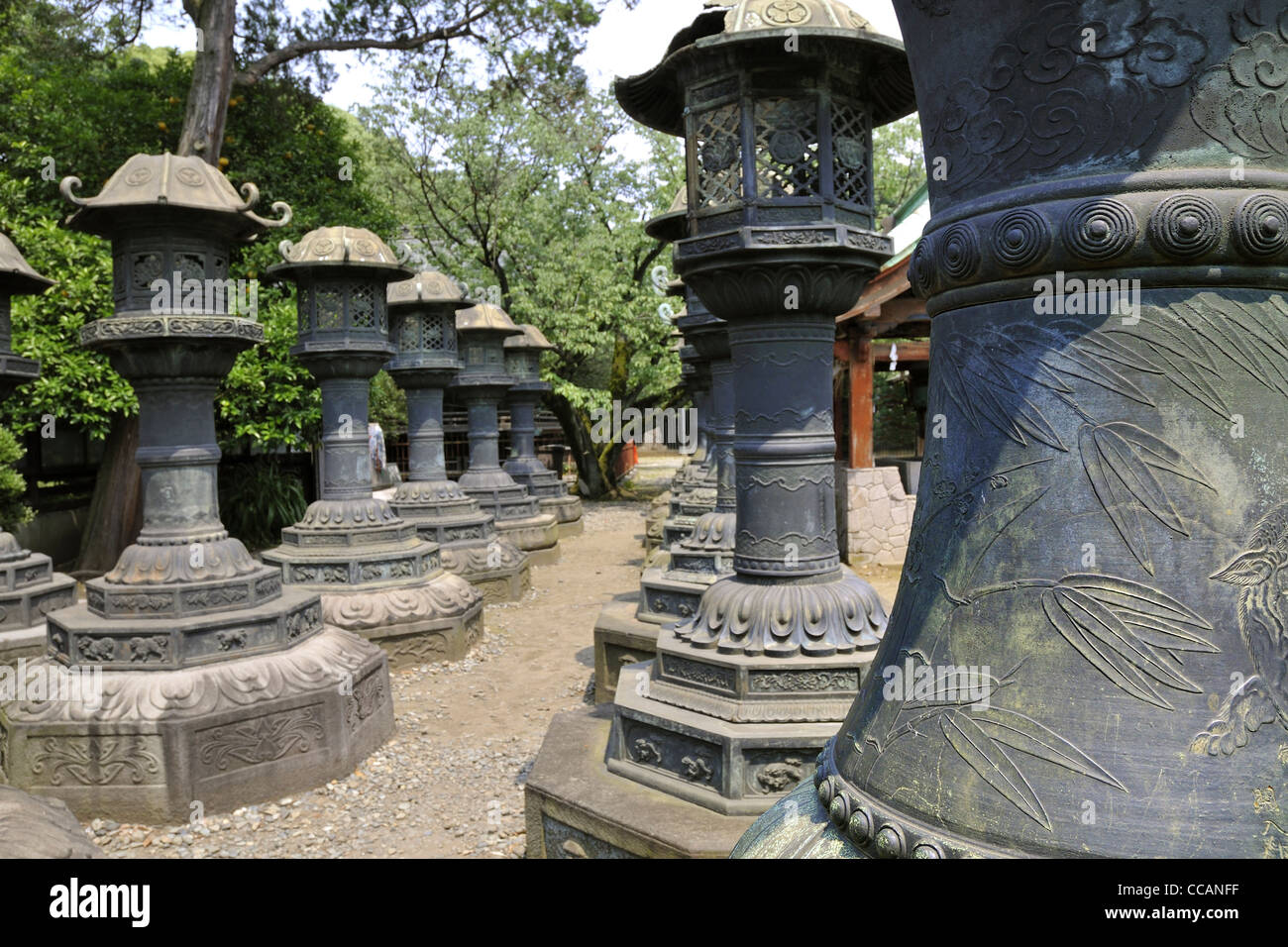 Rows of Japanese traditional stone lanterns in Tokyo Ueno park; focus on front lantern Stock Photo