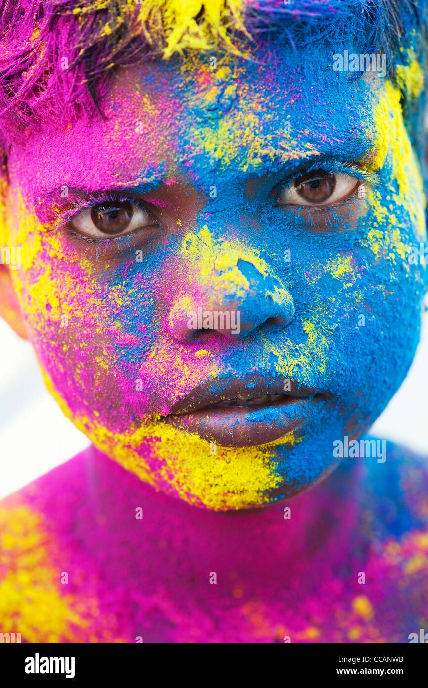 Young Indian boy covered in coloured powder pigment. India Stock Photo
