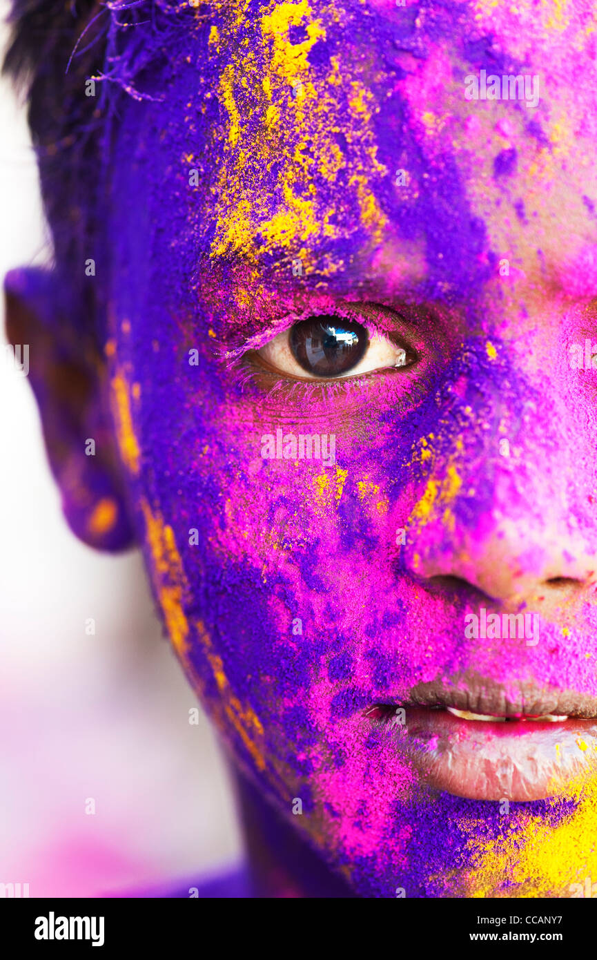 Young Indian boy covered in coloured powder pigment. India Stock Photo
