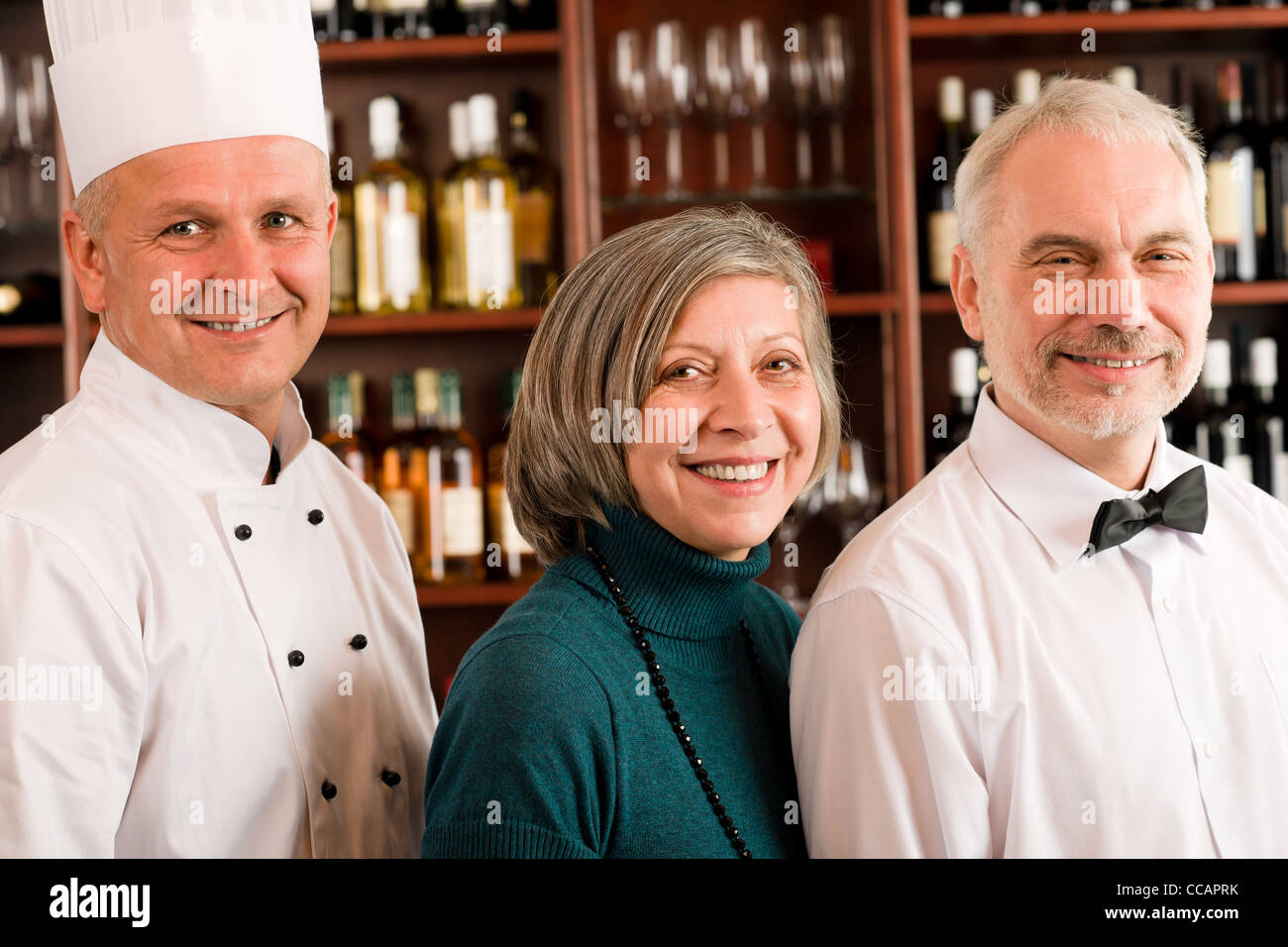 Restaurant manager posing with chef cook and waiter wine bar Stock Photo