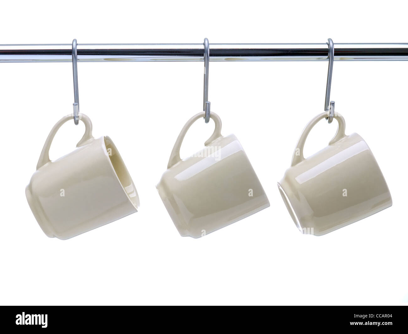 Three beige coffee cups hanging on metal railing on white background Stock Photo